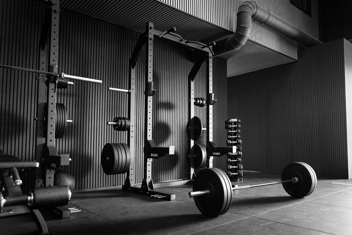 A power rack with a loaded barbell on the lifting floor