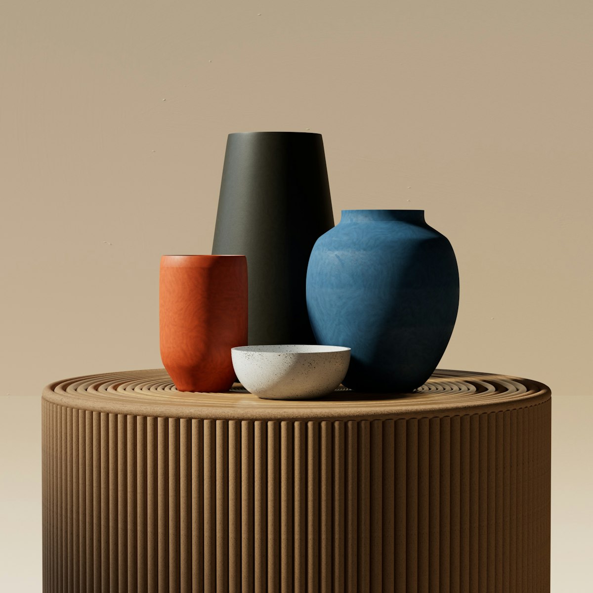 Three vases in black, blue and rust on a ribbed table